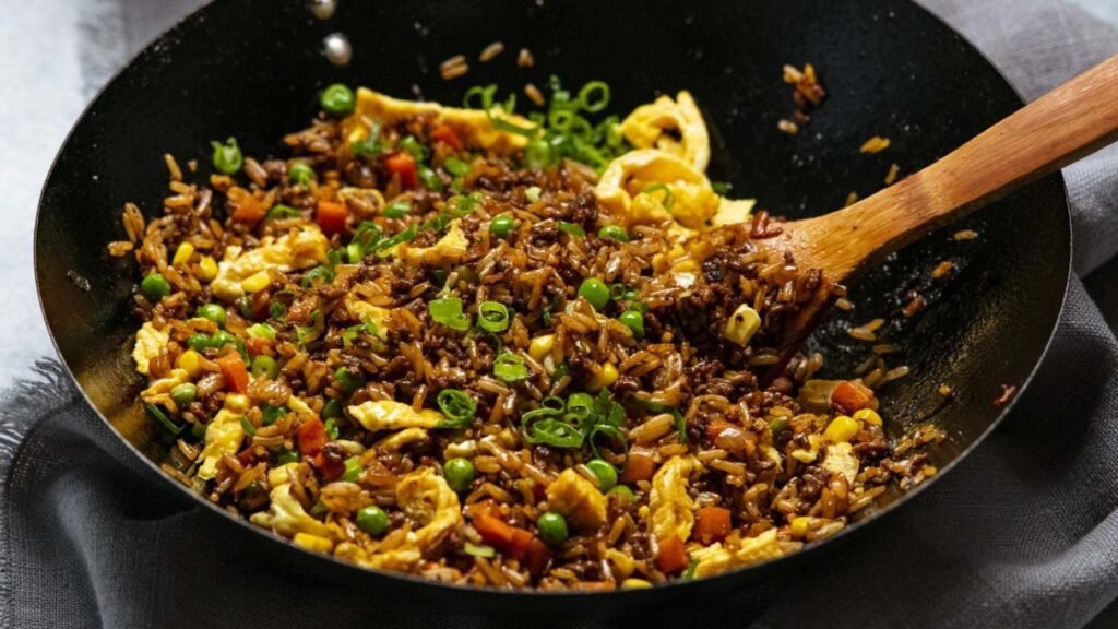 Chicken fried rice with egg and green onions served in a wok